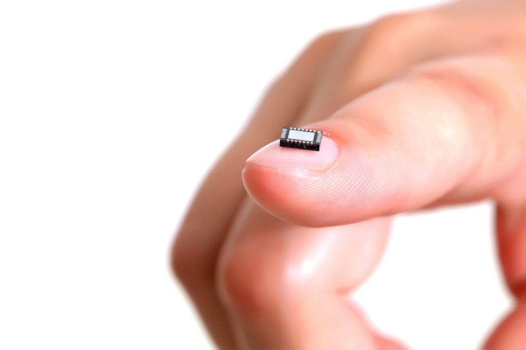 Computer microchip on girl's fingernail. Microelectronics conception