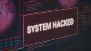Computer monitor showing hacked system alert message flashing on screen